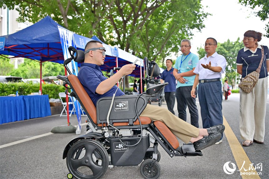 參觀者在科技助殘展區咨詢試用人工智能康復輔助器具產品。人民網 朱海鵬攝