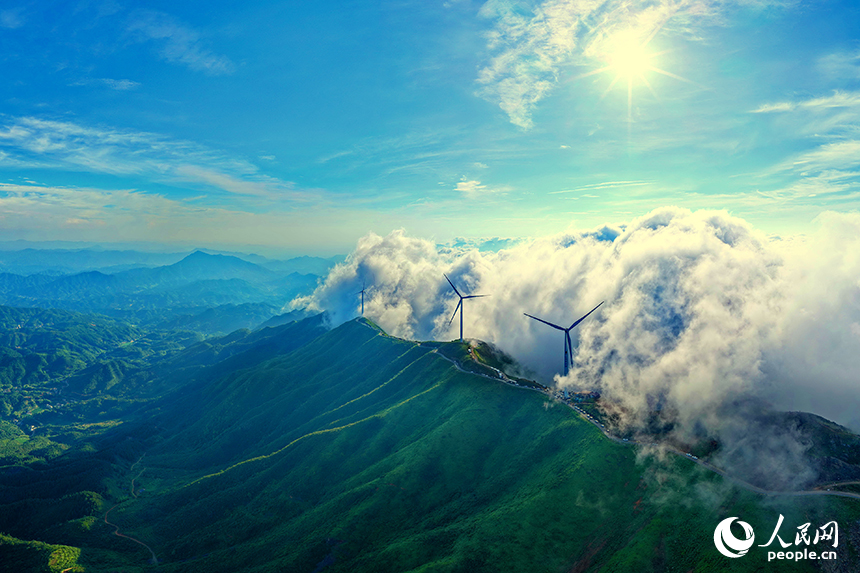 贛州市上猶縣雙溪草山，一臺臺風力發電機迎風旋轉，吸引許多游客前來觀賞“云蒸霞蔚、風葉飛旋”的獨特美景。人民網 朱海鵬攝