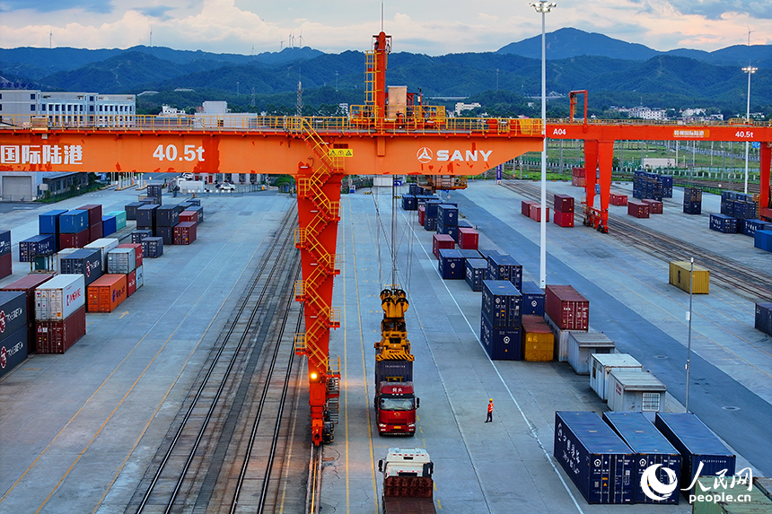 贛州市贛州國際陸港，吊裝設備在裝運進出口貨物集裝箱，貨場一派繁忙景象。人民網 朱海鵬攝