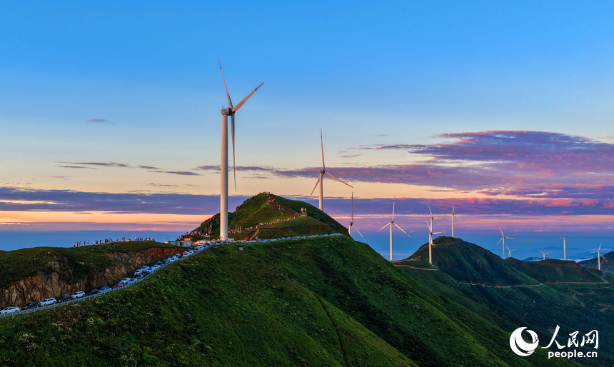 贛州市上猶縣的雙溪草山筑峰頂，新能源風力發電機組與連綿青山相映成景，吸引游客前來觀光打卡。人民網 朱海鵬攝