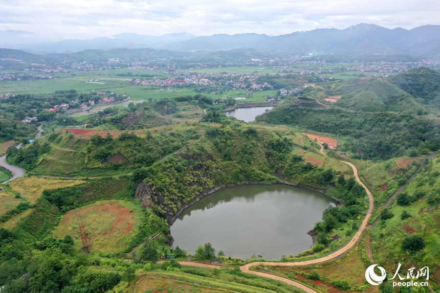 采礦區經過生態修復后披上“綠裝”，與不遠處的民居交相輝映。人民網記者 時雨攝