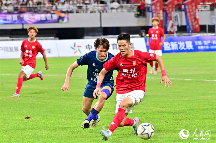 “贛超”第八輪比賽中，贛州隊球員與吉安隊球員在場上激烈拼搶。人民網 朱海鵬攝