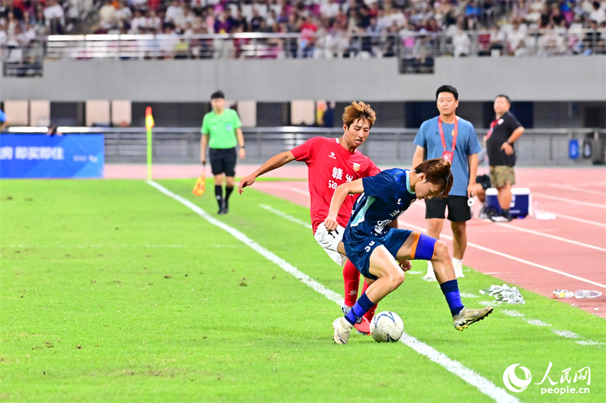 “贛超”第八輪比賽中，贛州隊球員與吉安隊球員在場上激烈拼搶。人民網 朱海鵬攝