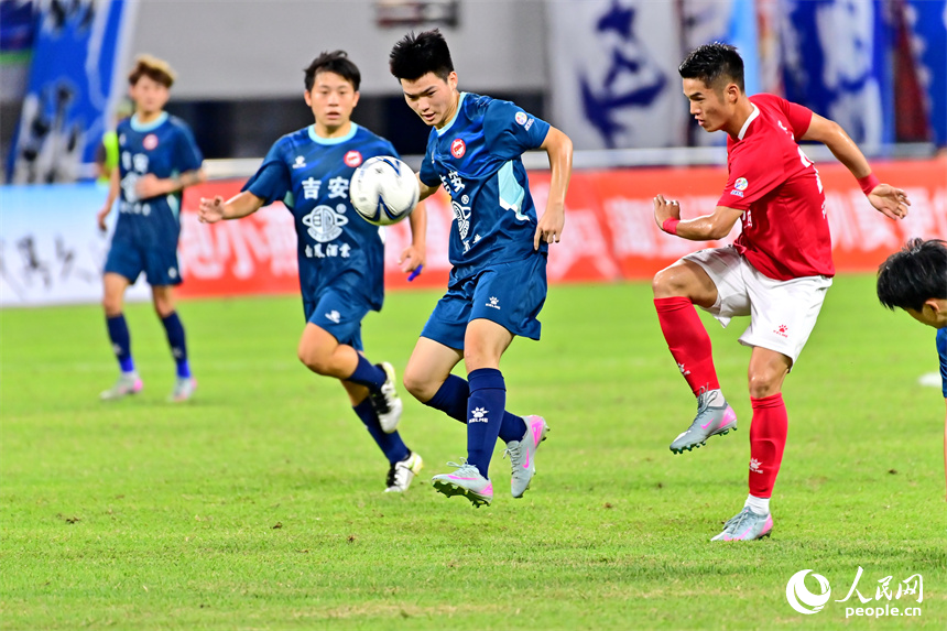 “贛超”第八輪比賽中，贛州隊球員與吉安隊球員在場上激烈拼搶。人民網 朱海鵬攝