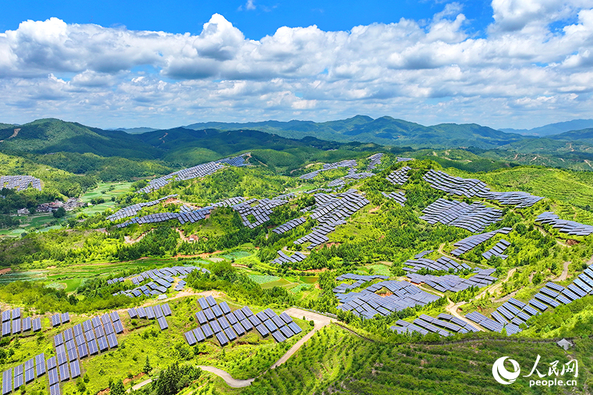 贛州市石城縣琴江鎮的一處光伏發電基地，鱗次櫛比的太陽能光伏板與青山綠樹、村莊田園相映襯，大地如同披上藍色“外衣”。人民網 朱海鵬攝
