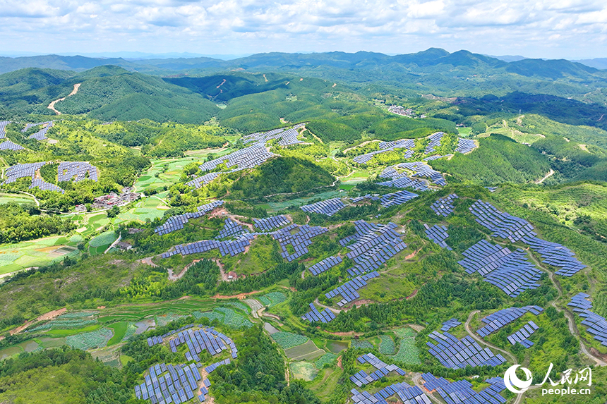 贛州市石城縣琴江鎮的一處光伏發電基地，鱗次櫛比的太陽能光伏板與青山綠樹、村莊田園相映襯，大地如同披上藍色“外衣”。人民網 朱海鵬攝