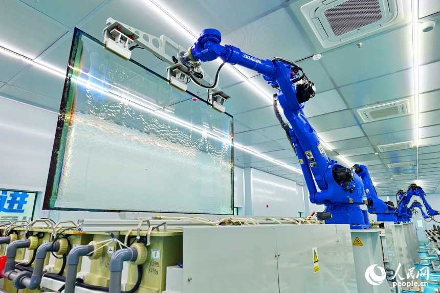 安遠縣產城新區的一家光電科技有限公司智能化生產車間內，一排排機器人揮舞著機械臂加緊作業。人民網 朱海鵬攝