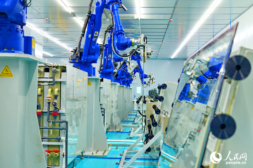 安遠縣產城新區的一家光電科技有限公司智能化生產車間內，一排排機器人揮舞著機械臂加緊作業。人民網 朱海鵬攝