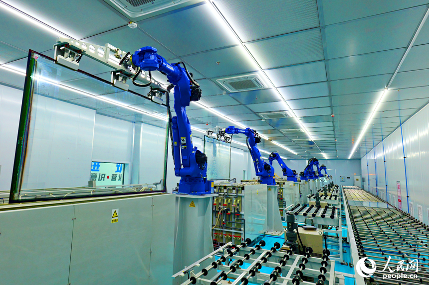 安遠縣產城新區的一家光電科技有限公司智能化生產車間內，一排排機器人揮舞著機械臂加緊作業。人民網 朱海鵬攝