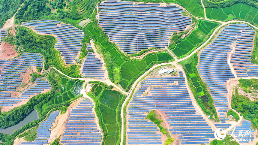 德興市香屯街道蘭村村20MW集中式光伏電站，荒山坡上的一排排光伏發電板熠熠生輝，源源不斷地輸出綠色電能。人民網 朱海鵬攝