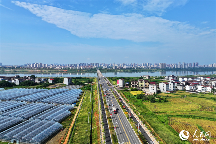 撫州市東臨新區湖南鄉店下村，撫河沿岸城市建筑與鄉村田園相互映襯，構成一幅水清岸綠的城鄉美景畫卷。人民網 朱海鵬攝