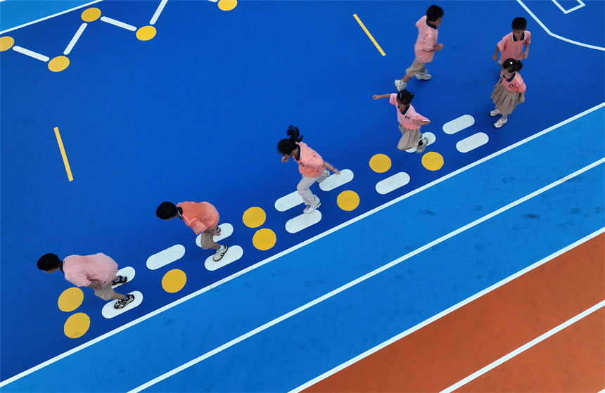 操場上，學生們在參加足球運動“彩繪格子陣”趣味體育活動。鄧龍華攝