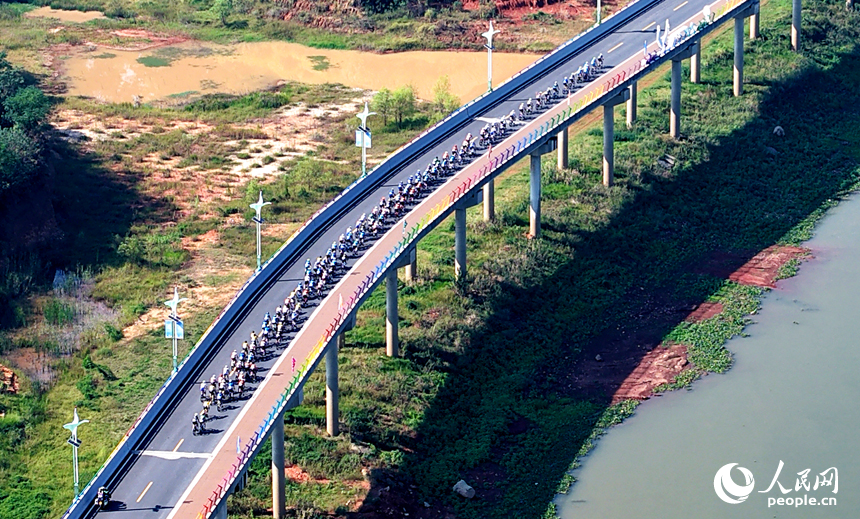 第十三屆環鄱陽湖國際自行車大賽永修站16日在永修縣吳城鎮啟航，圖為選手們在賽道競速。人民網記者 時雨攝