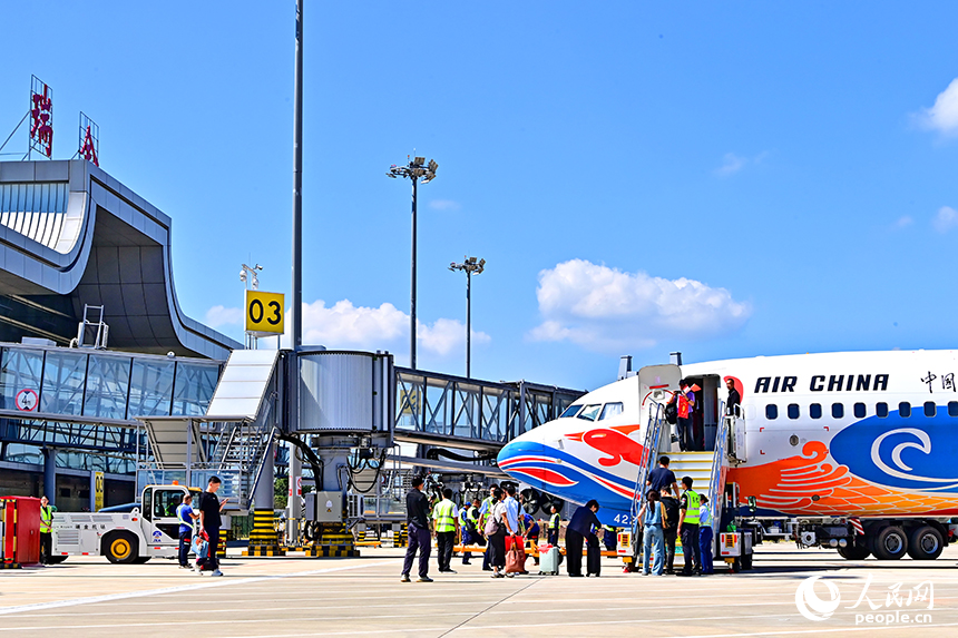 贛州瑞金機場停機坪，游客在搭乘瑞金飛往北京的CA8698航班。人民網 朱海鵬攝