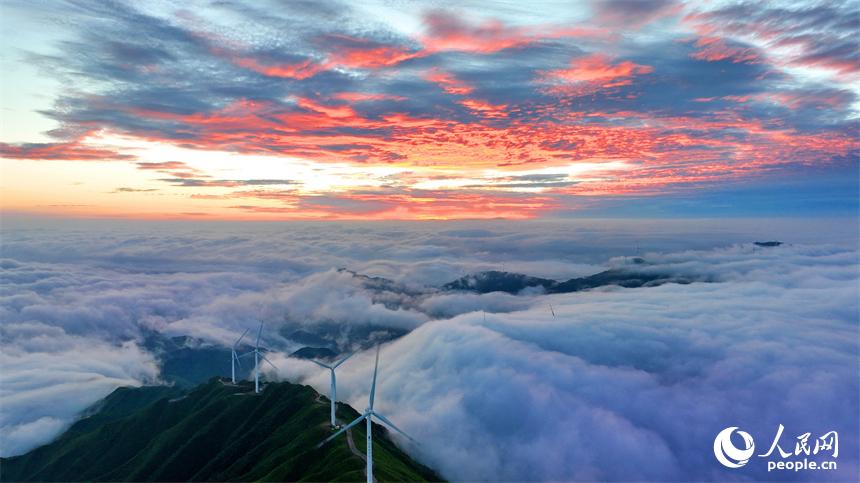 贛州市上猶縣雙溪草山云蒸霞蔚，一臺臺風力發電機迎風旋轉，與延綿群山相映成景，壯美如畫。人民網 朱海鵬攝