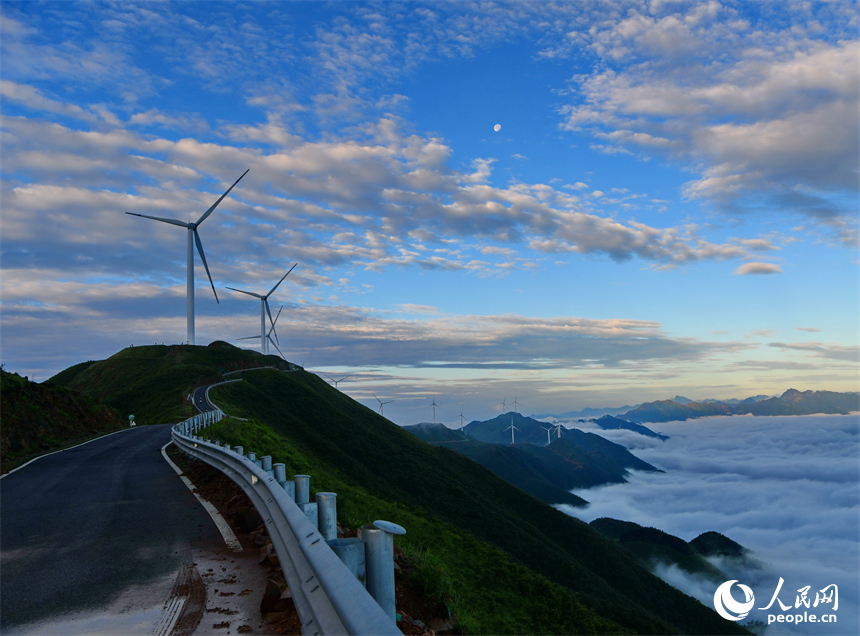 贛州市上猶縣雙溪草山云蒸霞蔚，一臺臺風力發電機迎風旋轉，與延綿群山相映成景，壯美如畫。人民網 朱海鵬攝