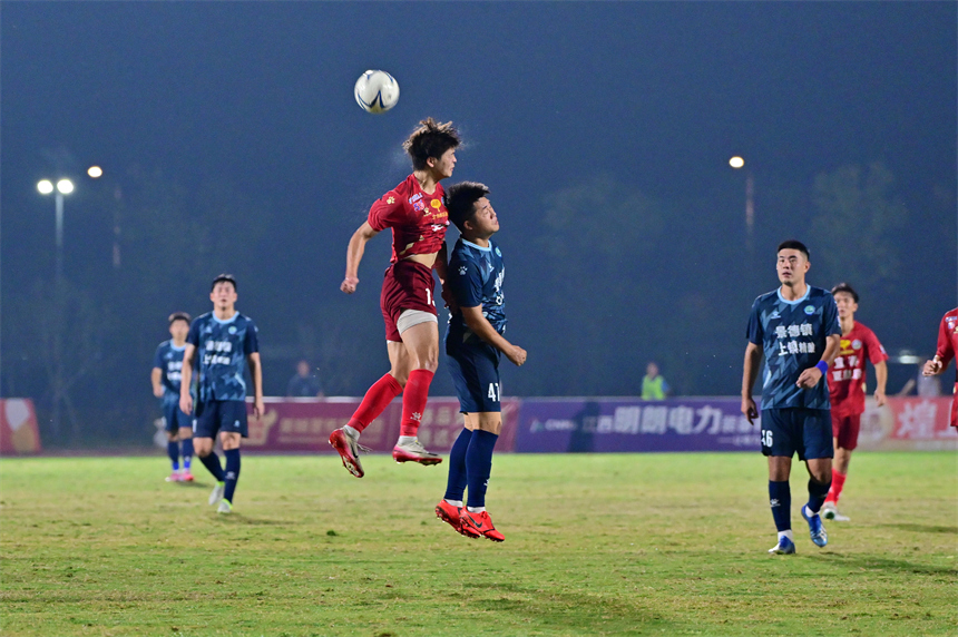 身穿紅色球員的宜春隊球員和身穿藍色球衣的景德鎮球員在綠茵場上激烈拼搶。劉勇攝