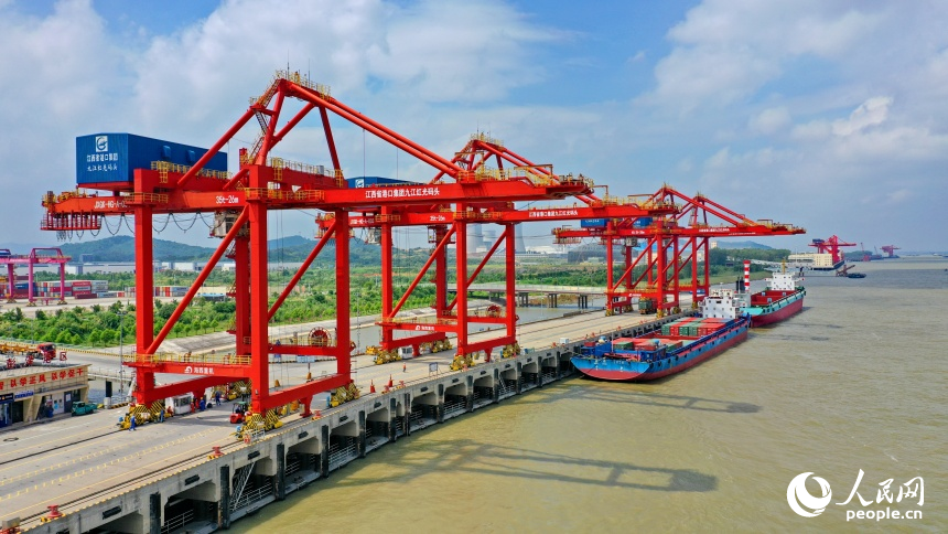 九江市彭澤縣的九江紅光國際港，碼頭貨輪穿梭，工人堅守崗位一線，集裝箱裝卸作業有序進行。人民網 朱海鵬攝