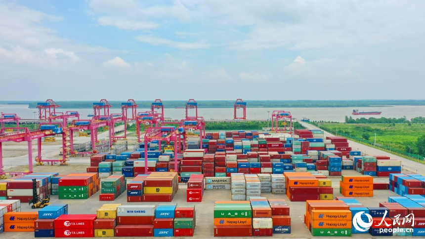 九江市彭澤縣的九江紅光國際港，碼頭貨輪穿梭，工人堅守崗位一線，集裝箱裝卸作業有序進行。人民網 朱海鵬攝