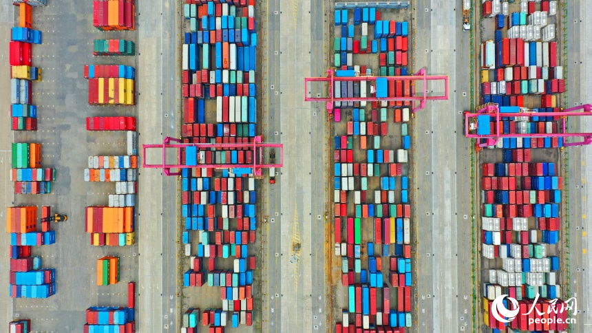 九江市彭澤縣的九江紅光國際港，碼頭貨輪穿梭，工人堅守崗位一線，集裝箱裝卸作業有序進行。人民網 朱海鵬攝