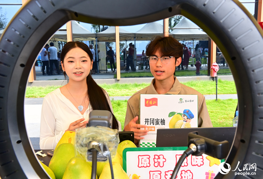 活動現場，參加網絡直播銷售擂臺賽的主播們通過直播助力井岡蜜柚銷售。人民網 朱海鵬攝