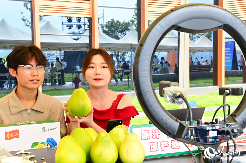 活動現場，參加網絡直播銷售擂臺賽的主播們通過直播助力井岡蜜柚銷售。人民網 朱海鵬攝