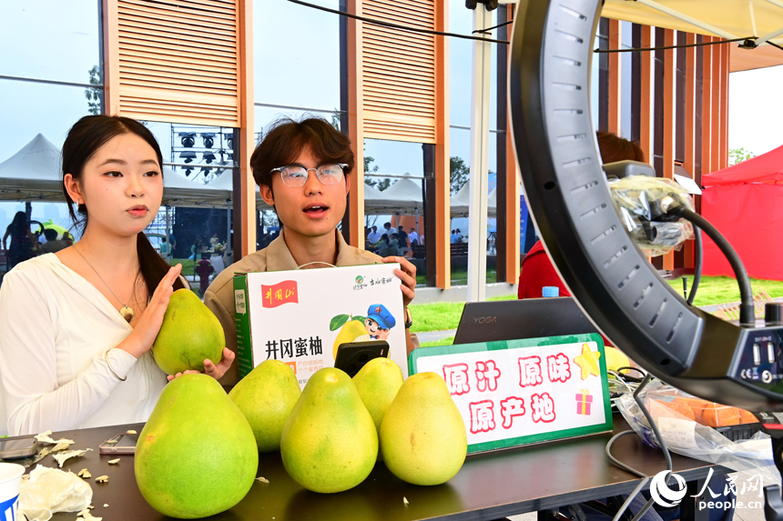 活動現場，參加網絡直播銷售擂臺賽的主播們通過直播助力井岡蜜柚銷售。人民網 朱海鵬攝