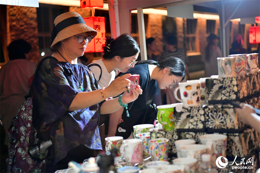 游客在春秋大集的攤位上挑選心儀的瓷器。人民網記者 時雨攝