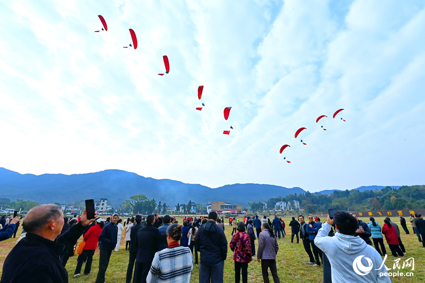 南康區龍回鎮布谷寨航空飛行營地，動力傘編隊、滑翔傘表演和比賽吸引眾多游客前來觀看。人民網記者 朱海鵬攝