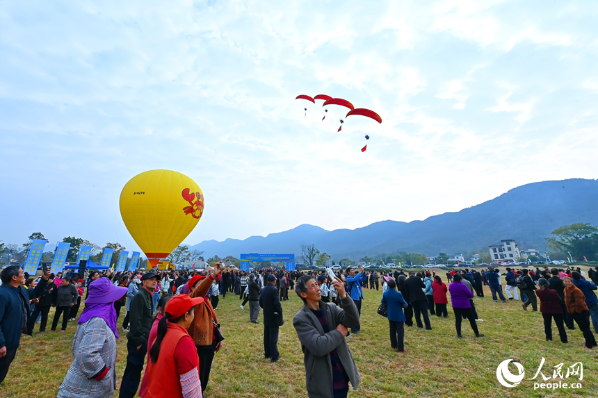 南康區龍回鎮布谷寨航空飛行營地，動力傘編隊、滑翔傘表演和比賽吸引眾多游客前來觀看。人民網記者 朱海鵬攝